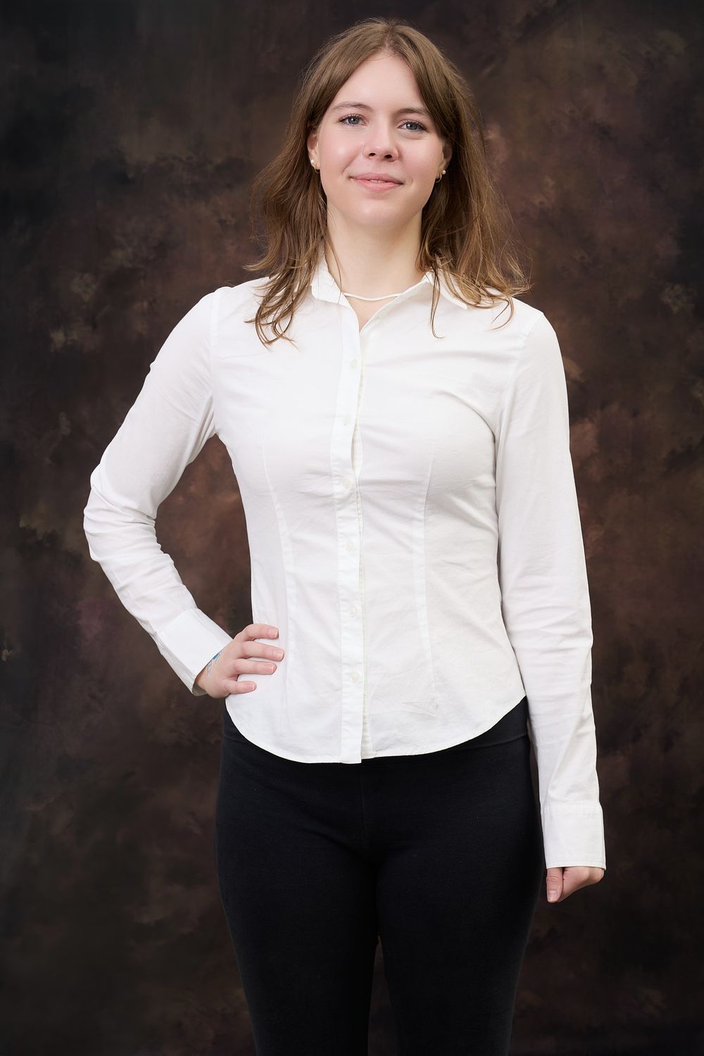 Professional portrait series of a person in a crisp white button-down shirt and dark pants against a mottled brown backdrop.