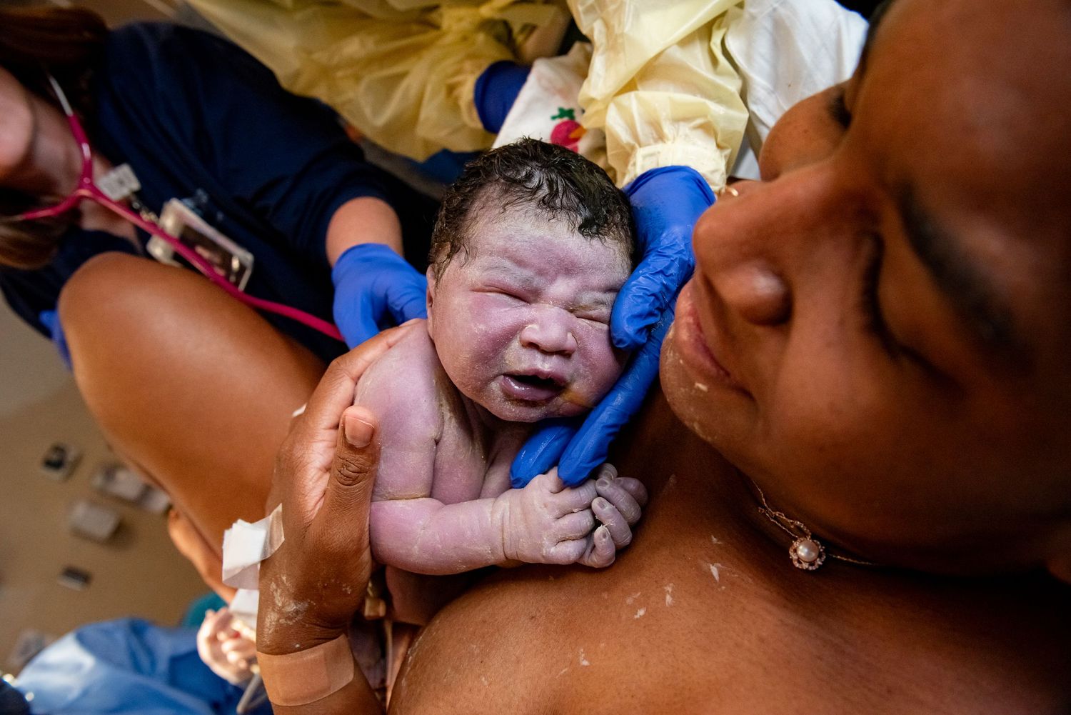 A collage of newborn babies being held and cleaned by medical staff in a hospital setting.