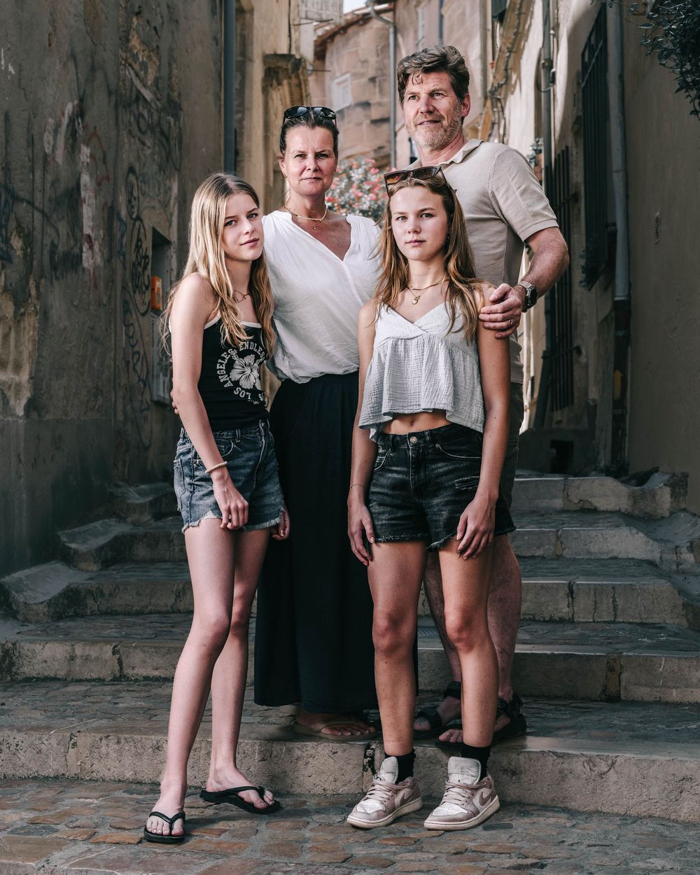 A group of people pose together on ancient stone steps in an atmospheric alleyway setting.