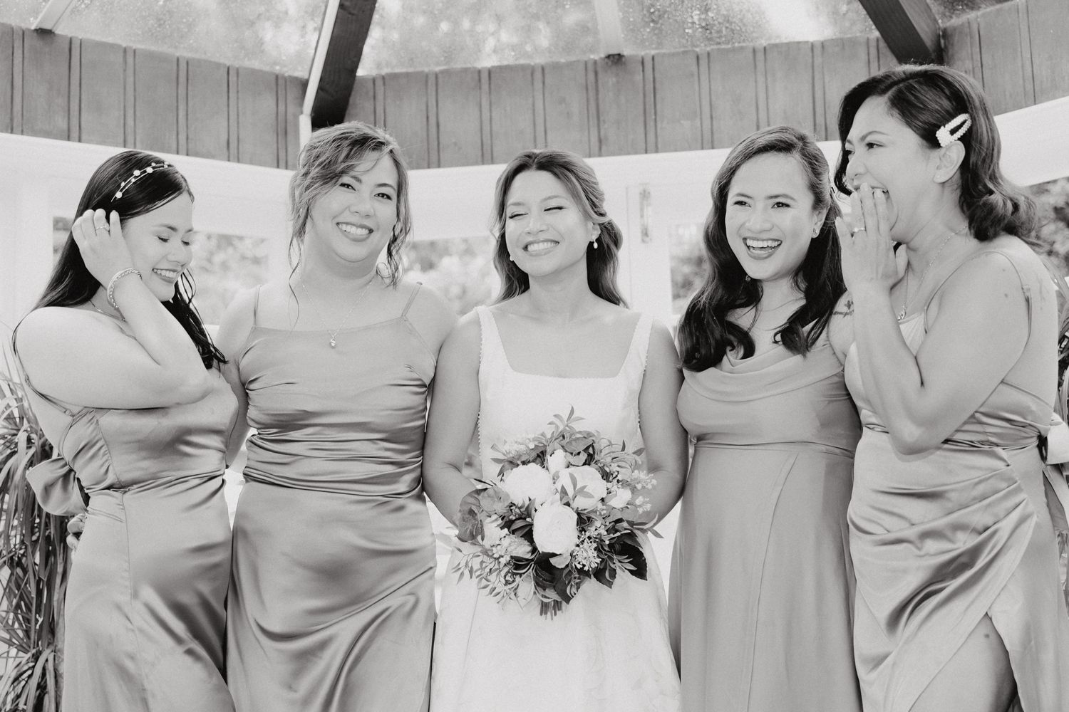 Black and white photo of bridesmaids in silk dresses captured by Apertured Media Auckland Wedding Photographer.