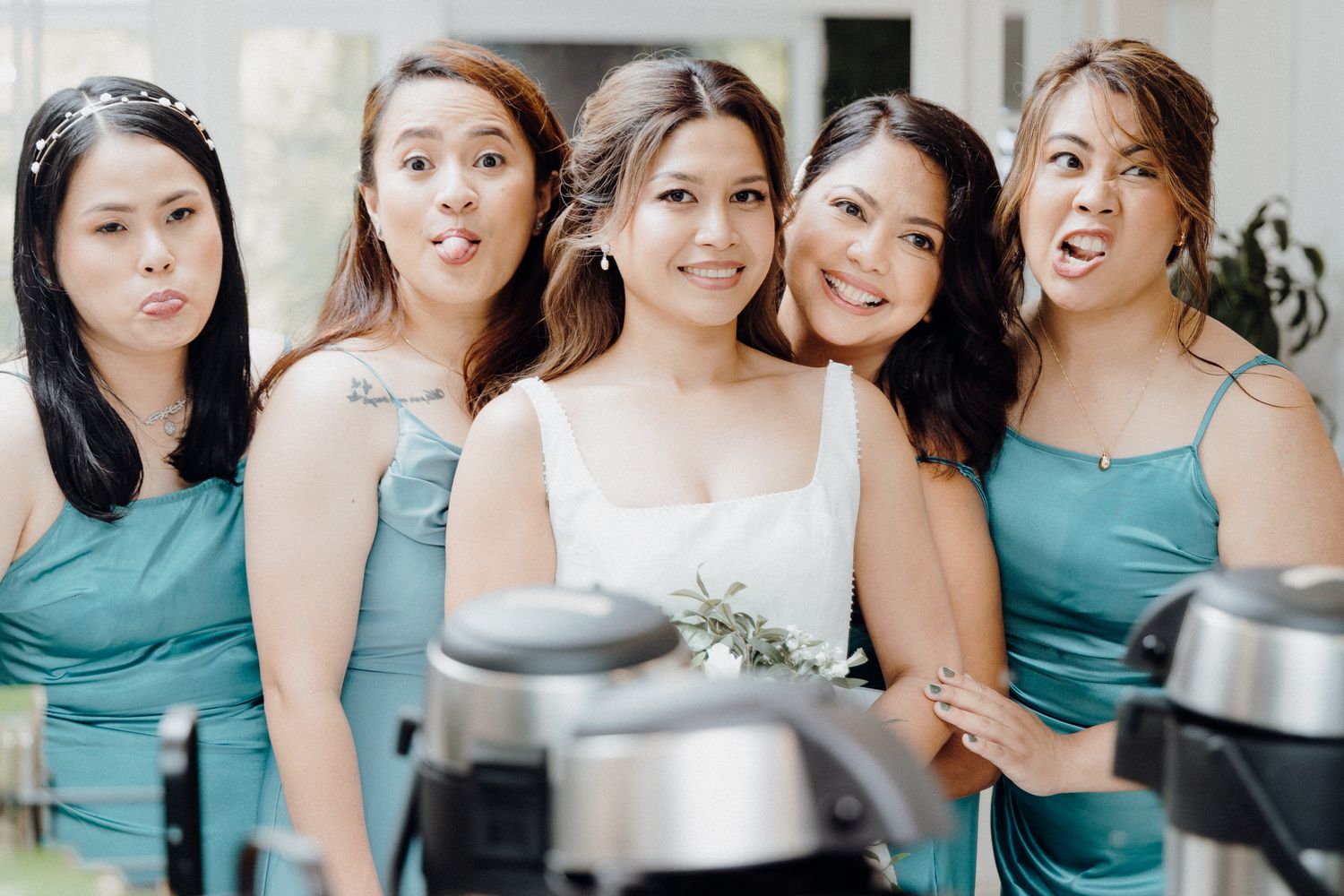 A group of friends wearing teal and white dresses pose together in celebration captured by Apertured Media Auckland Wedding Photographer.