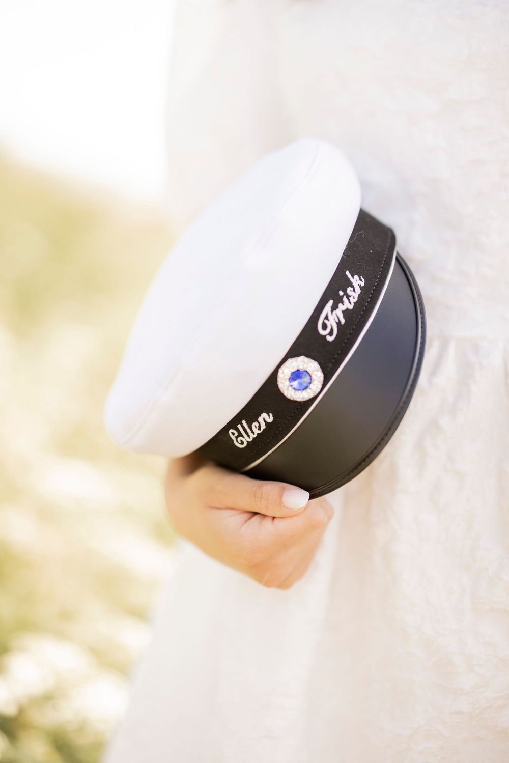 Black and white ceramic Fosters beer bowl with logo held against blurred natural background.