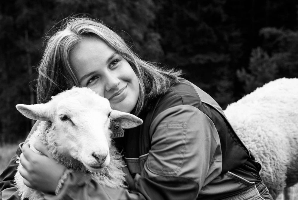 Jetne som holder rundt en sau og smiler under konfrimantfotografering i Farsund