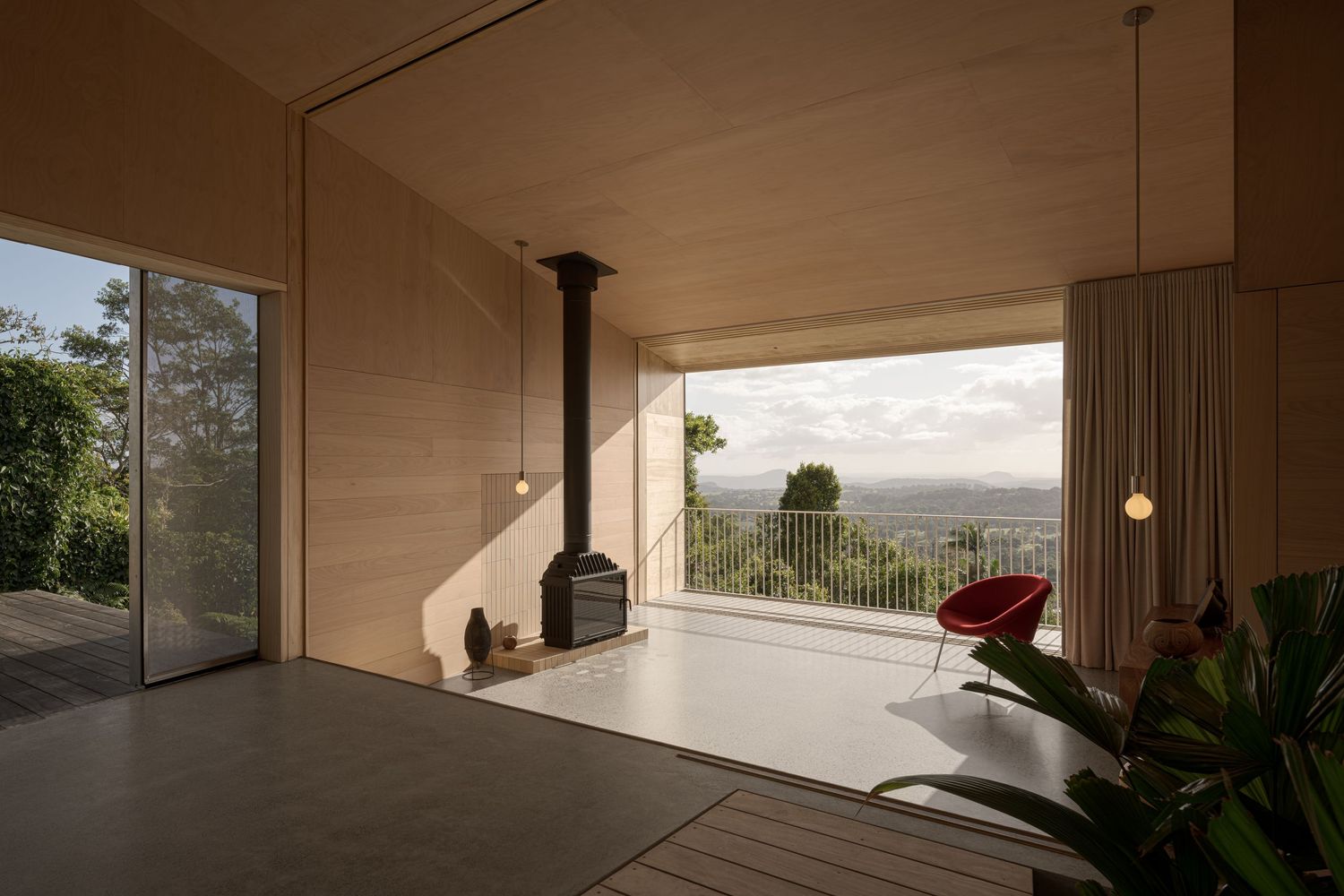 Minimalist covered patio with fireplace and panoramic views of rolling hills.