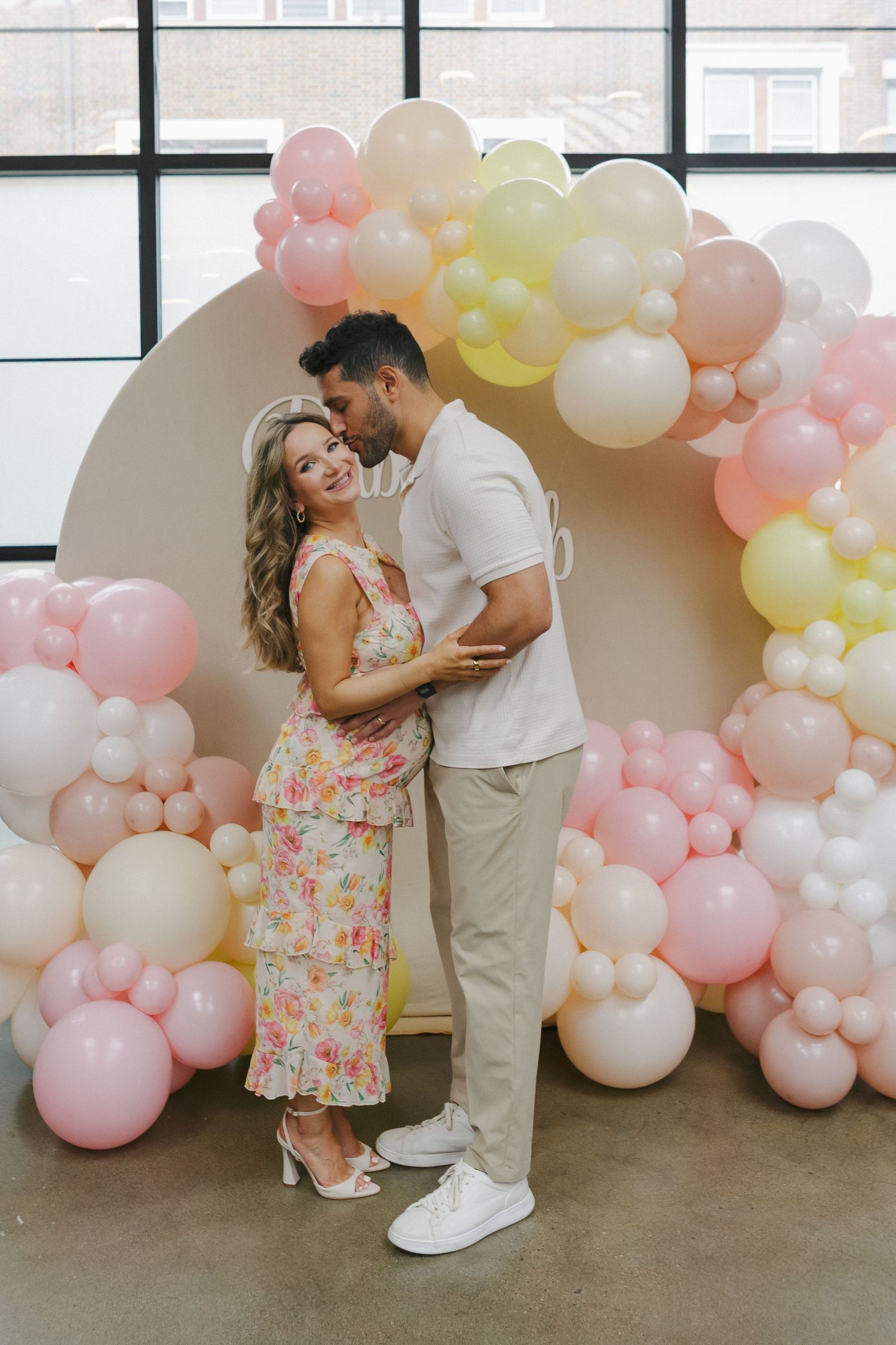 Romantic moment—mom and dad-to-be share a loving kiss, celebrating their journey to parenthood by NYC baby shower photographer Paula B