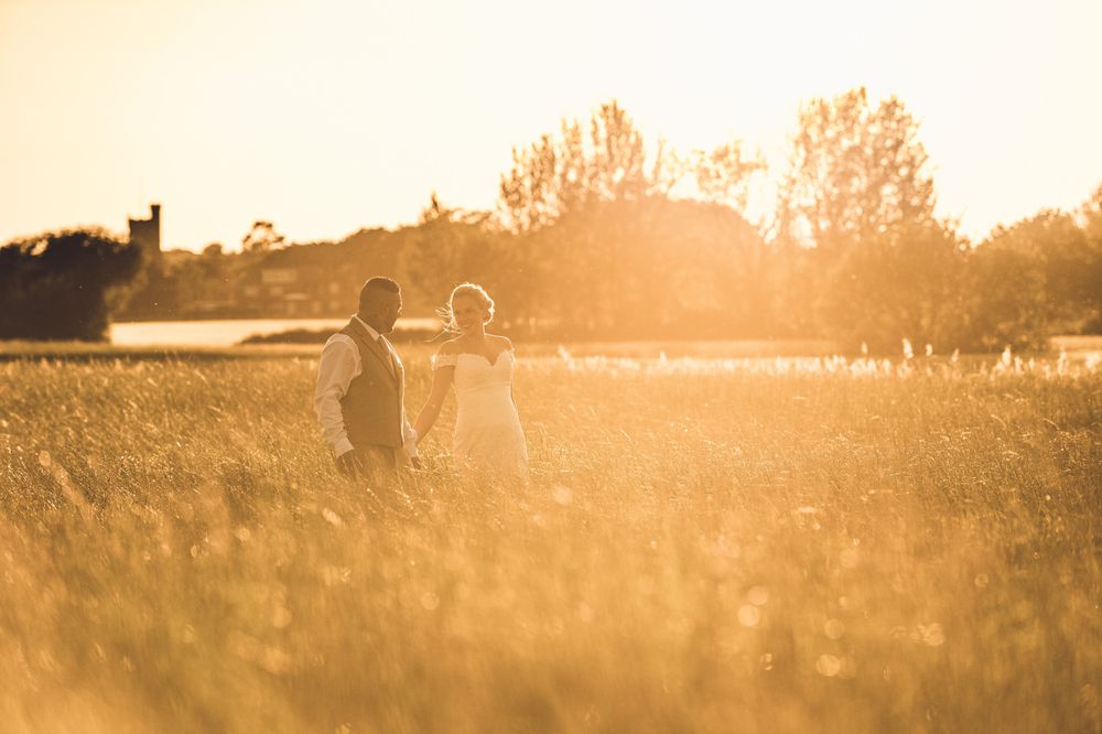 A walk in a field at sunset by a bride and groom at Quantock lakes
