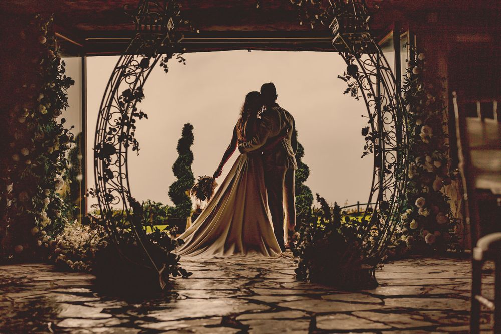 A bride and groom in the doorway of Ocean Kave looking out to sea