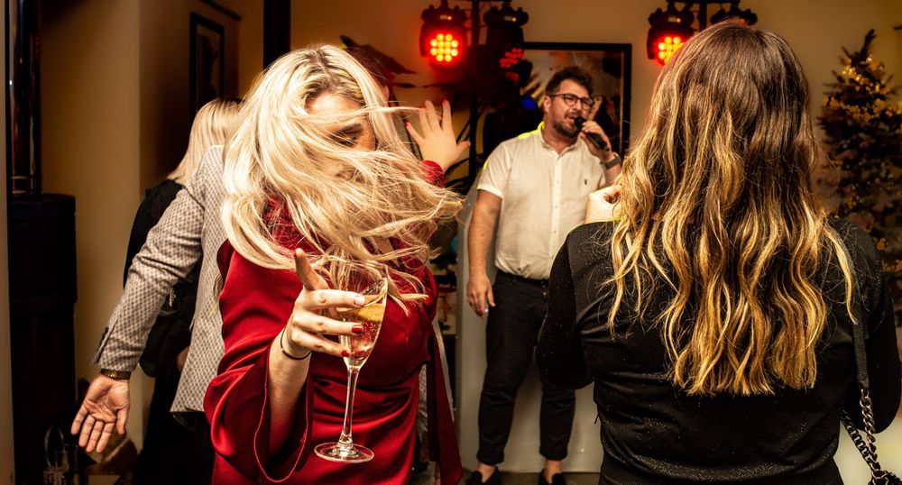 A woman dancing with a glass of wine in Exeter