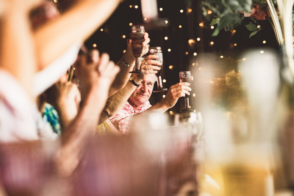 A man raising a glass during a toast at the wedding speeches