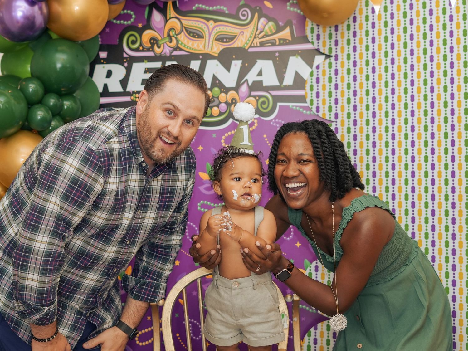 Family celebration with colorful balloon arch and decorative background.