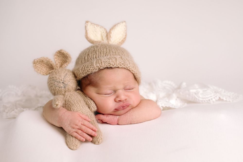 Buffalo In Home Newborn Session Photography. Newborn girl with bunny stuffed animal and bunny ears hat.