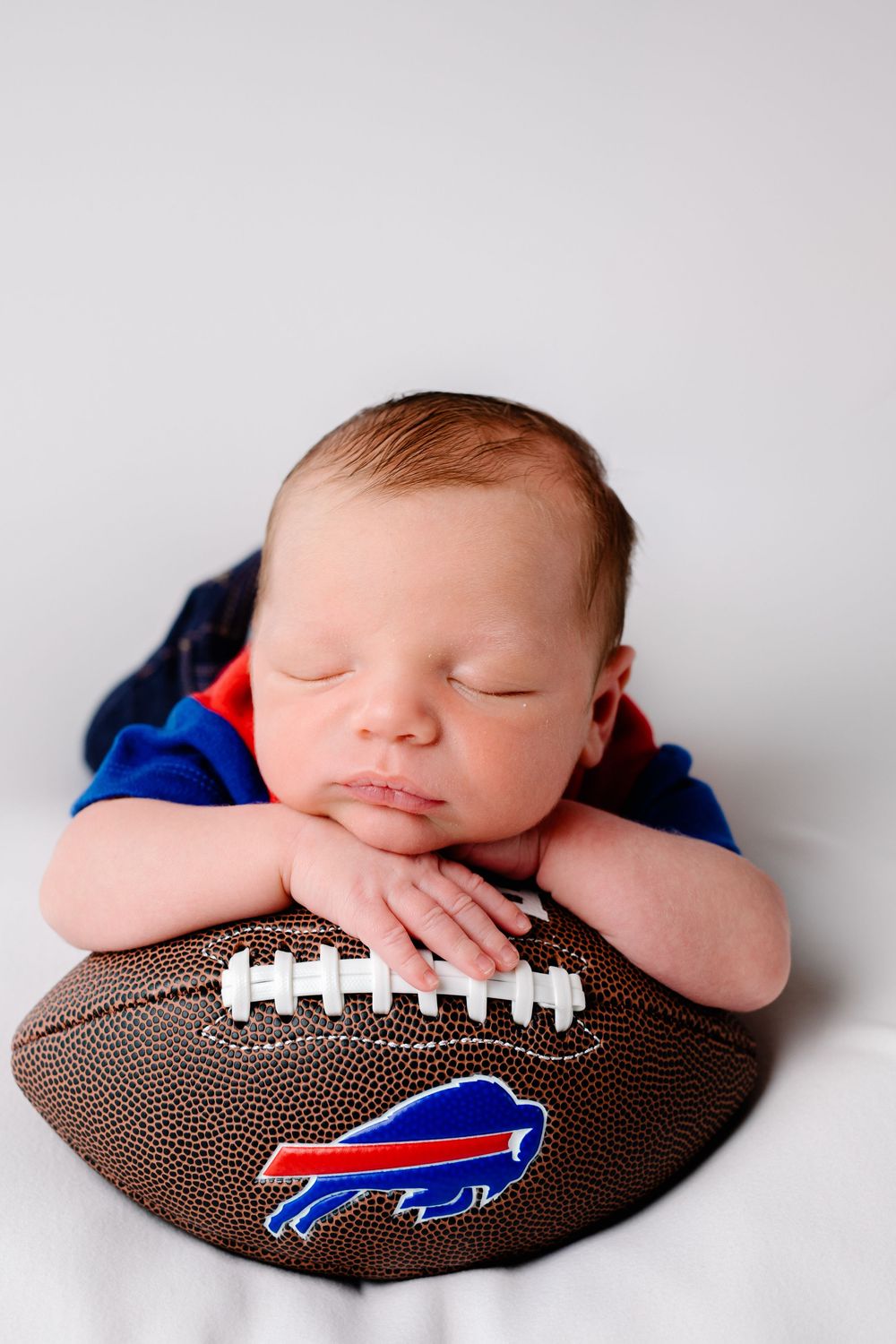 Buffalo In Home Newborn Session Photography. Newborn boy in Buffalo Bills Jersey and Buffalo Bills Baby Football.