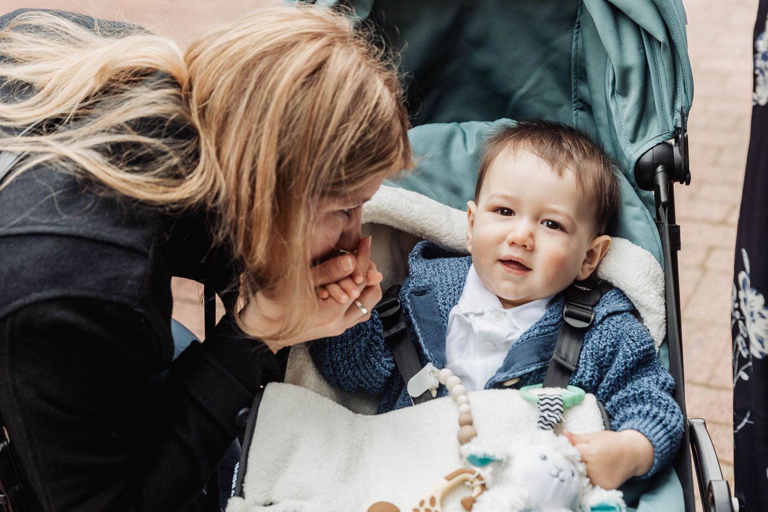 Close interaction with a young child sitting in a stroller wearing denim.