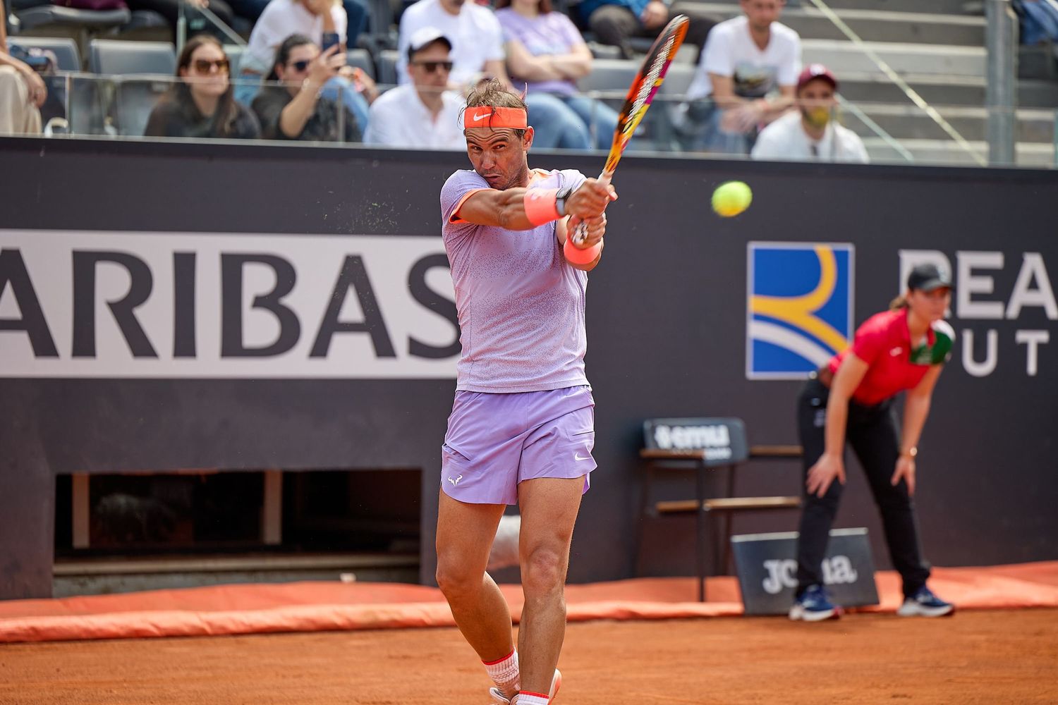 Tennis player executing a backhand shot on clay court at BNP Paribas tournament.
