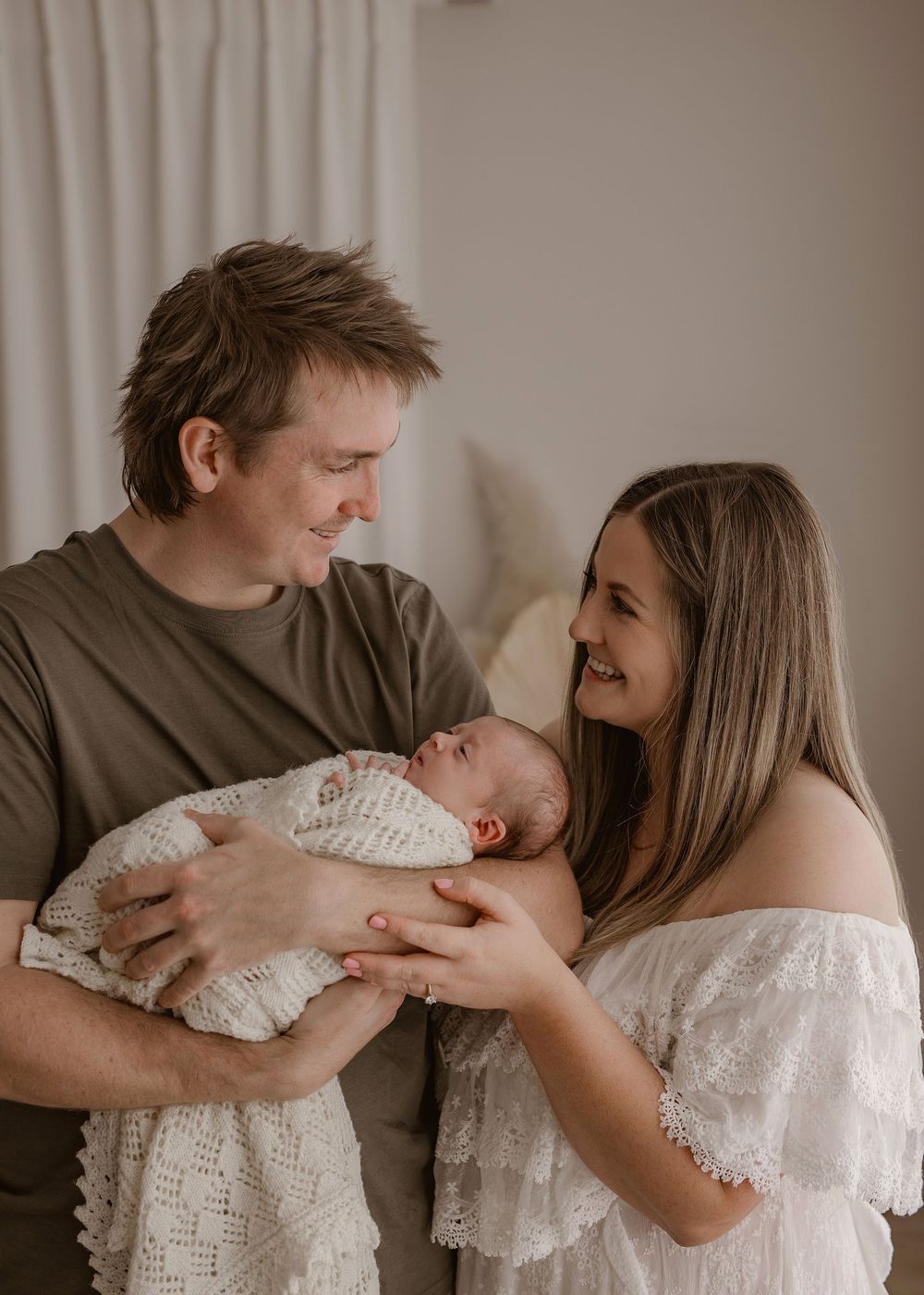 Three generations pose together in studio against neutral backdrop. Photographed in a studio located in Papamoa, Tauranga