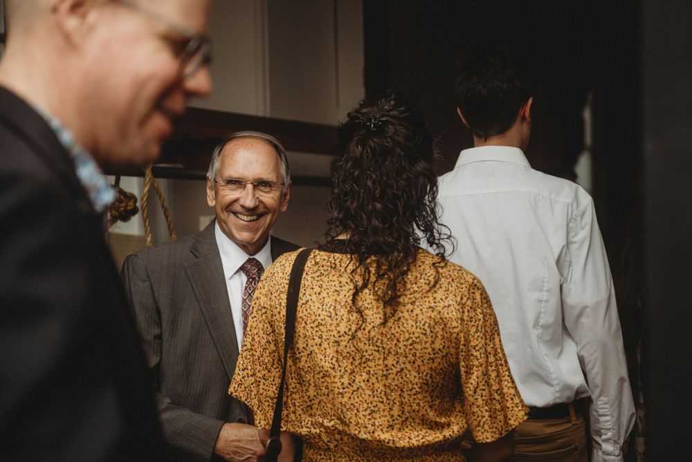 Wedding guests mingling during reception in casual indoor setting.