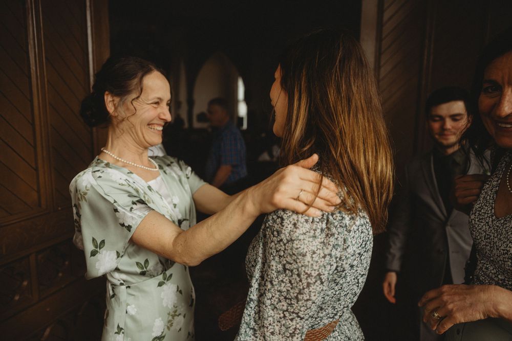 Wedding guests sharing joyful moment during indoor reception celebration.