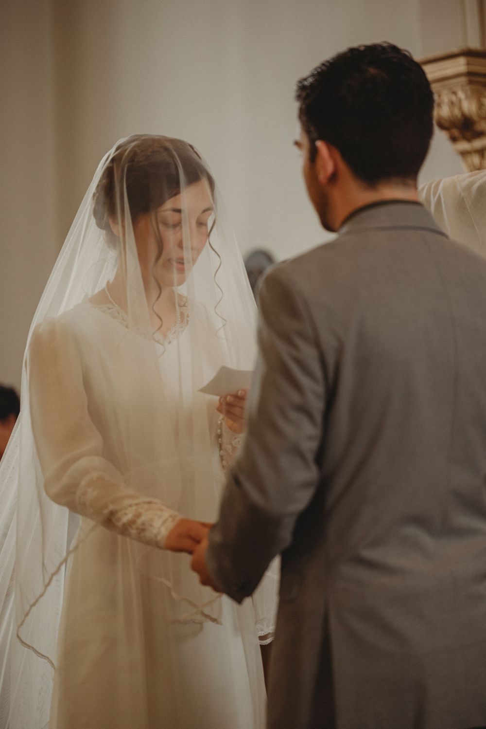 A couple exchanges vows during an intimate church wedding ceremony.