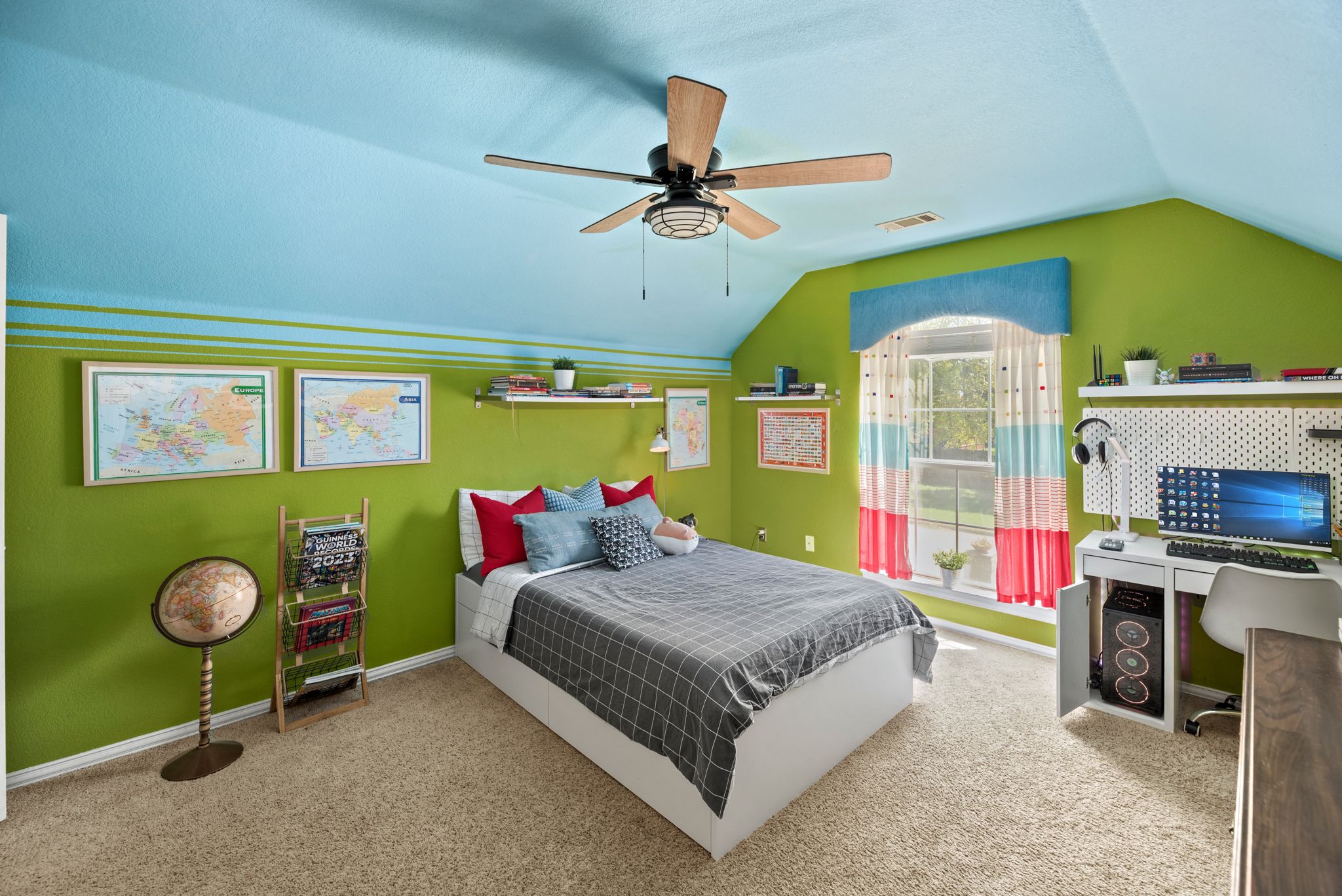 A bright teen bedroom with lime green walls, white furniture, ceiling fan, and built-in desk area with beige carpet.