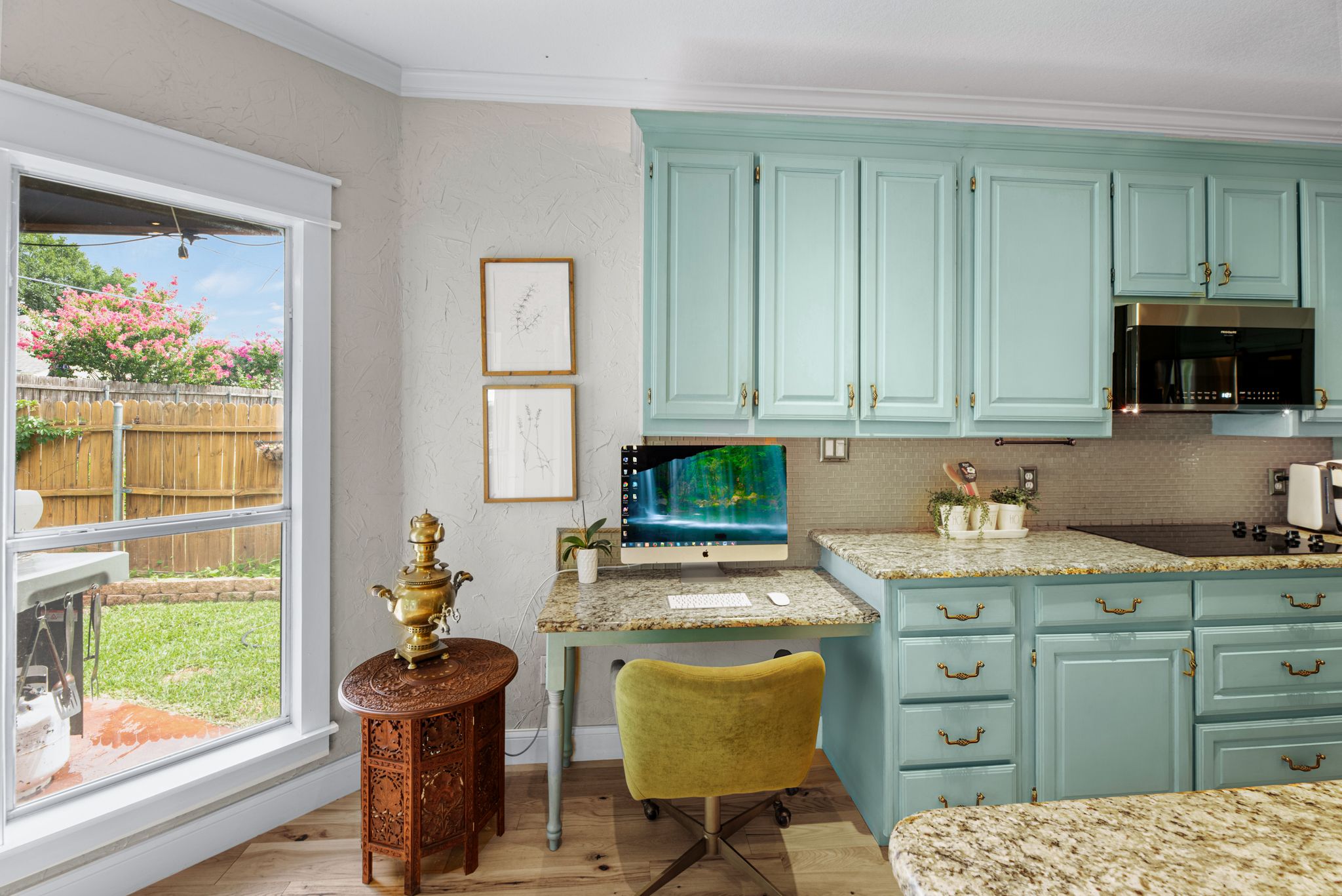 Modern kitchen design with mint green cabinets, wood accents, and bright natural lighting.