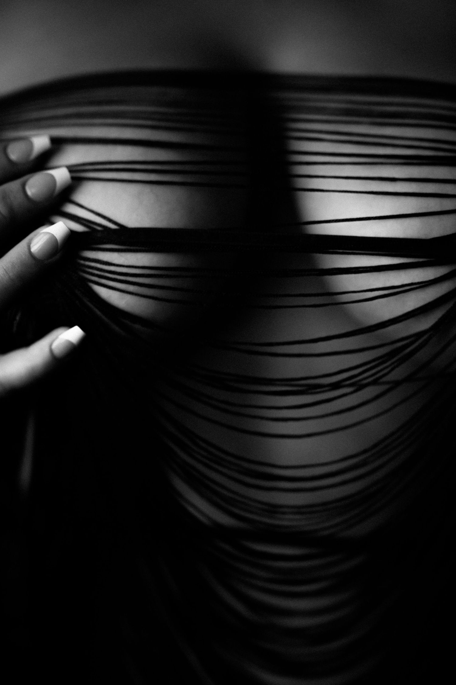 Abstract black and white detail of fabric with linear patterns and shadows.