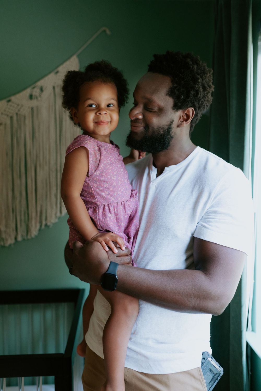 Sweet family photography showing a touching moment between dad and child sharing a joyful moment in-home.