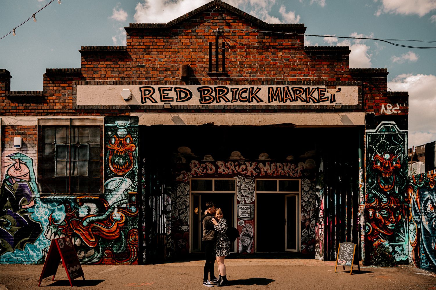 Colorful graffiti decorates the entrance of Red Brick Market, a brick building with street art-covered walls.