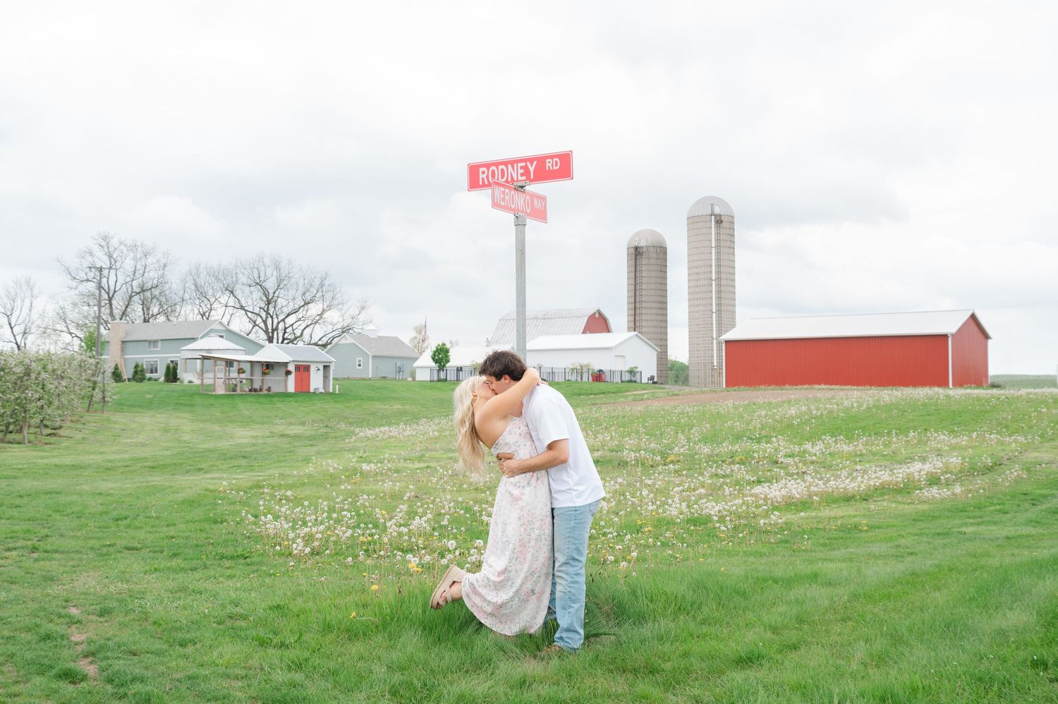 couple kissing in front of farm