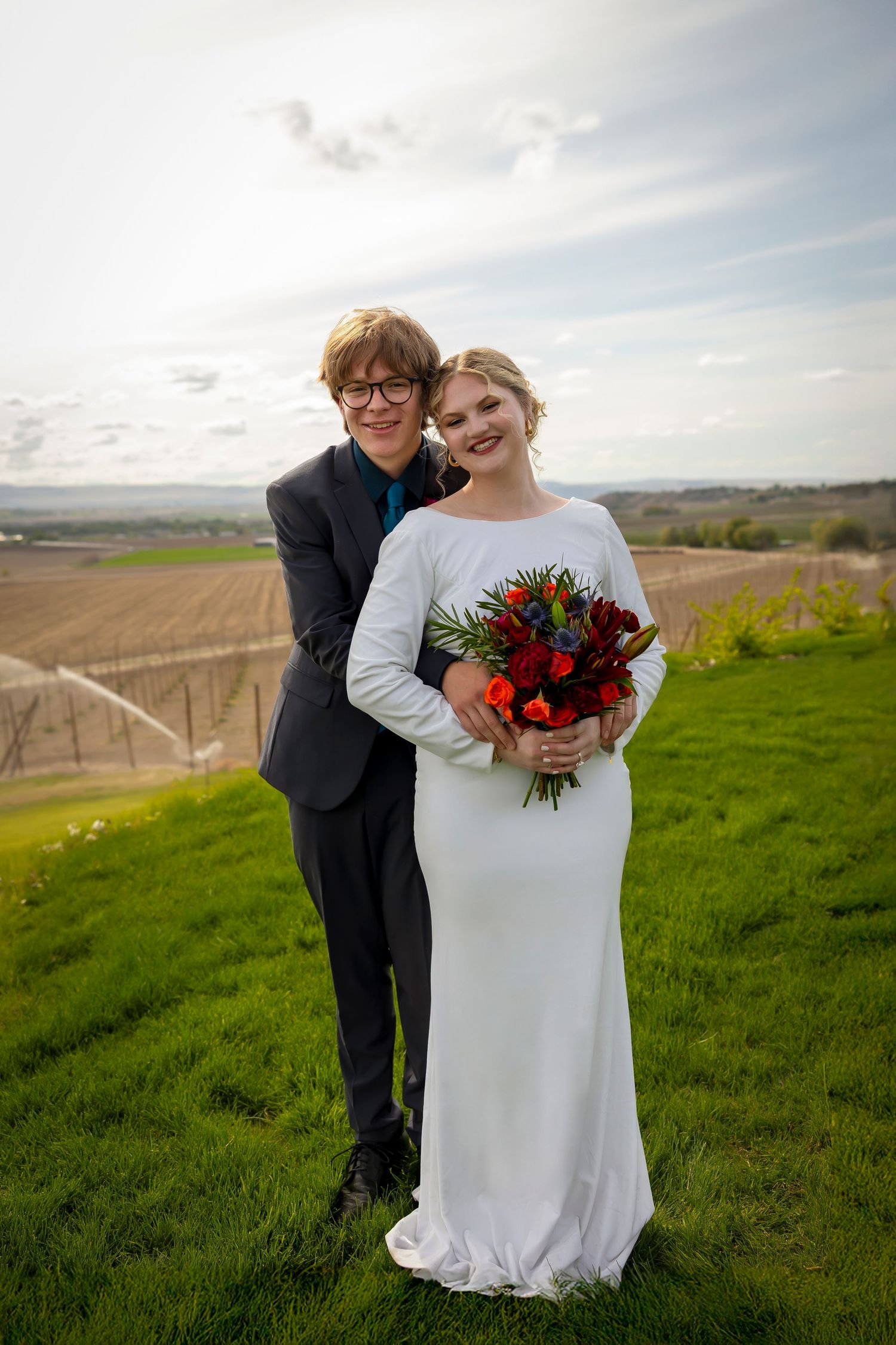 bride and groom embraced portrait on hillside