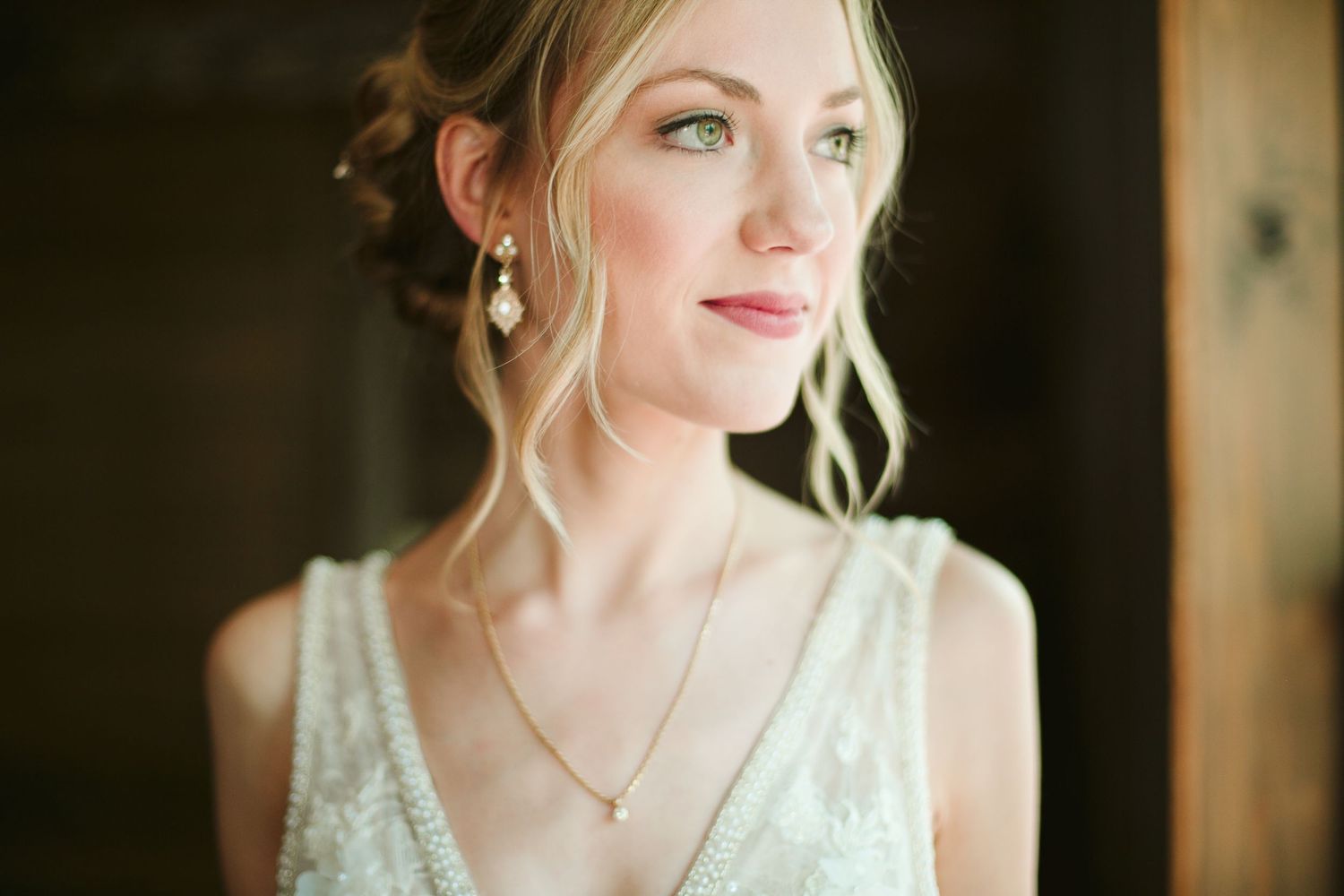 Close up portrait of bride wearing vintage inspired beaded gown and delicate jewelry.
