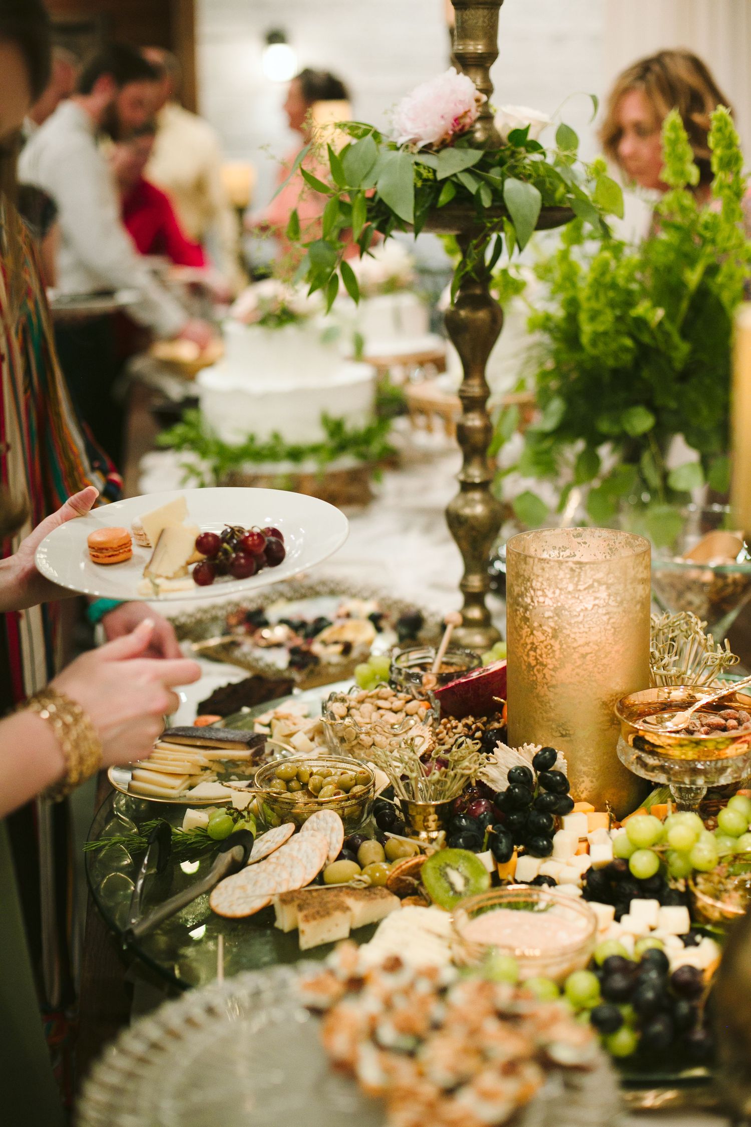 Elegant wedding reception buffet table with fresh fruits, candles and floral arrangements.
