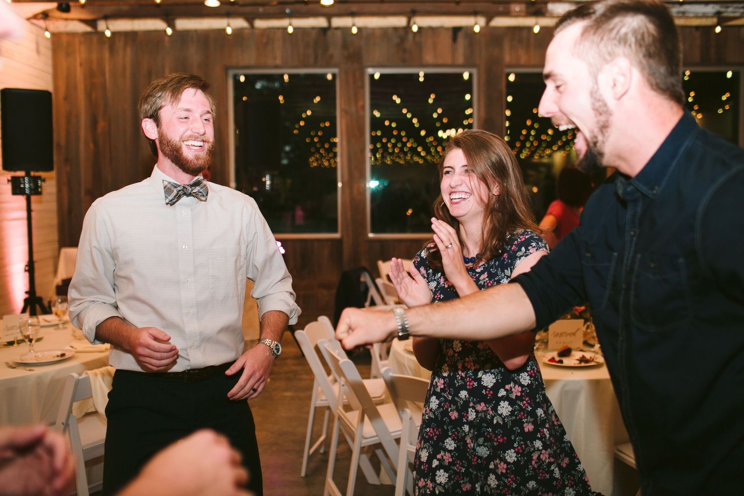 Wedding guests laughing and enjoying themselves at evening reception.