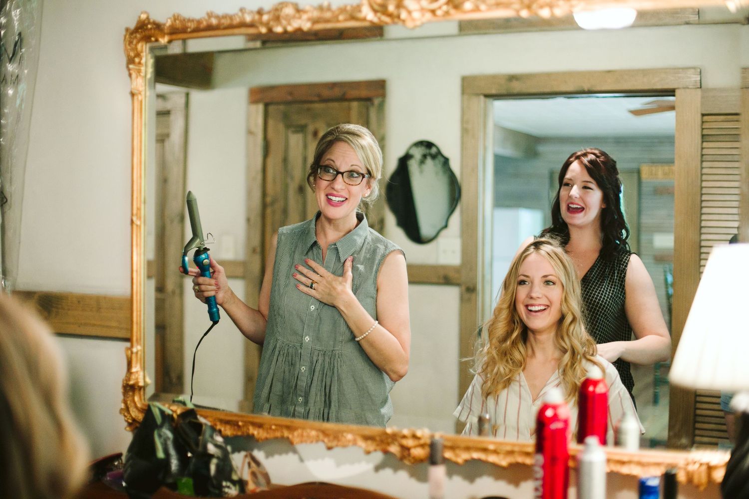 Getting ready scene with vintage mirrors and warm lighting in rustic room.