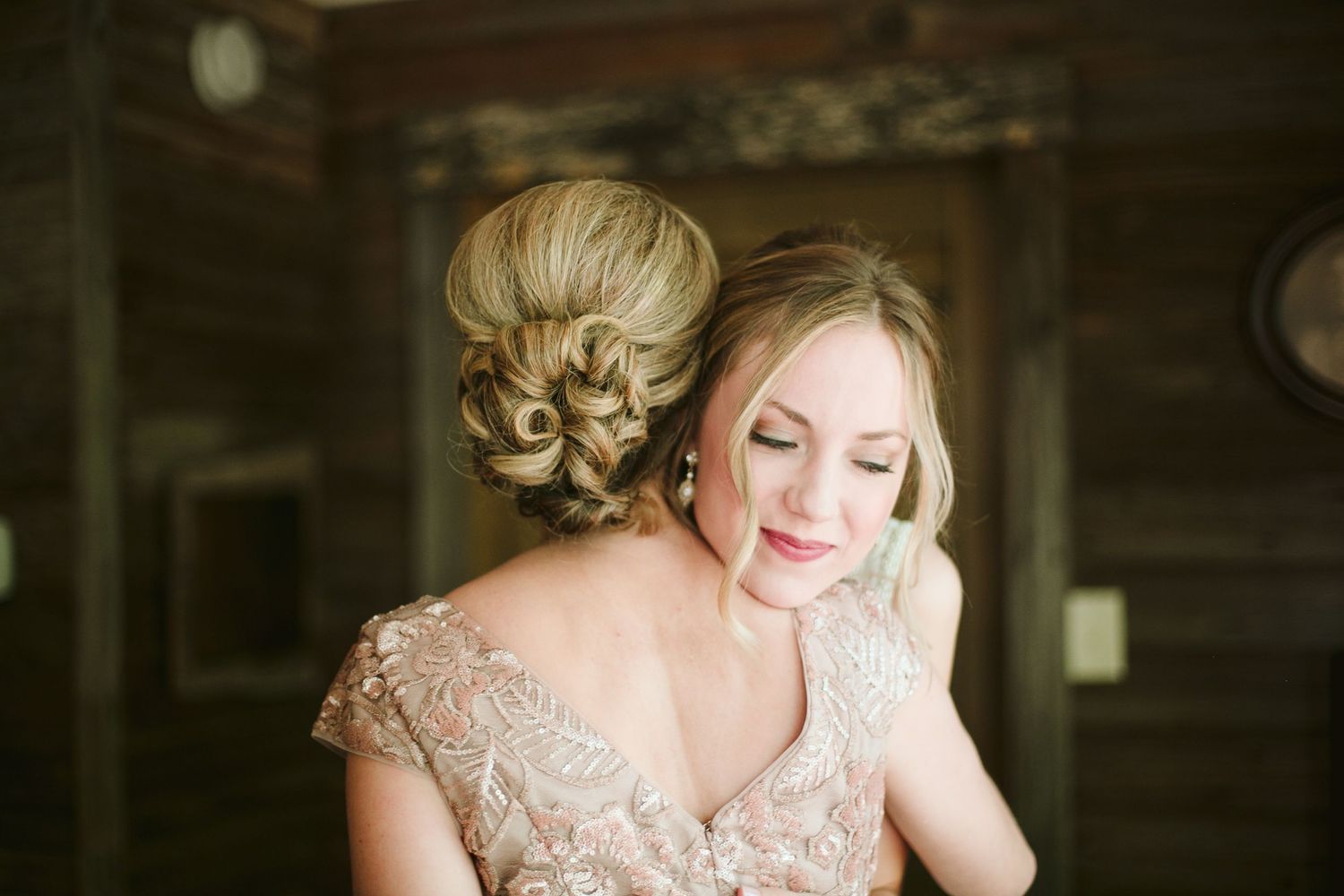 Romantic bridal portrait in rustic wooden cabin with elegant updo hairstyle.