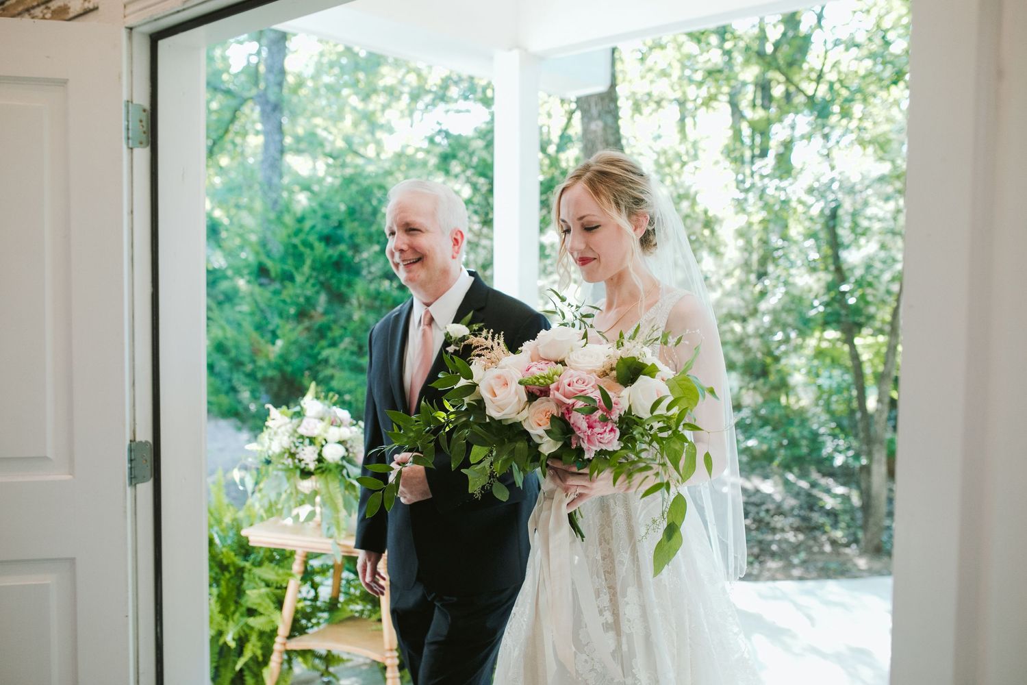 A walk down a sunlit hallway with a beautiful bouquet of pink and green flowers.