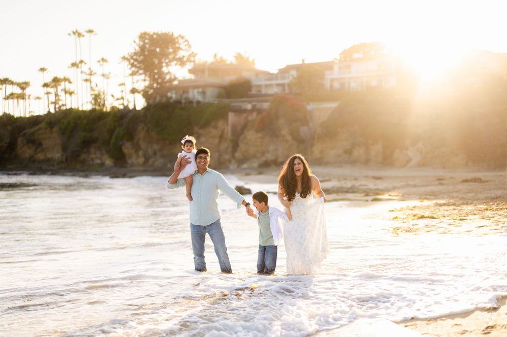 Family enjoying a playful moment at the beach during golden hour.