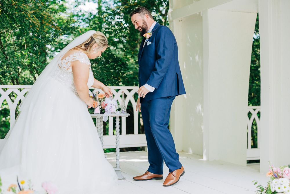 A romantic wedding moment on a white gazebo with delicate floral decor and brown shoes perfectly complementing the scene.