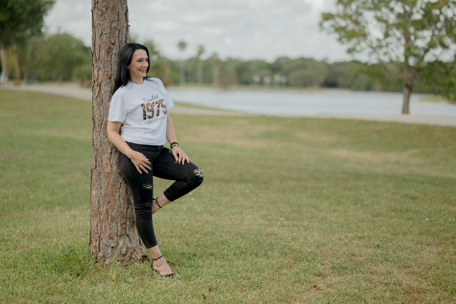 A series of outdoor portrait photos taken on grassy parkland with a lake and trees in the background.