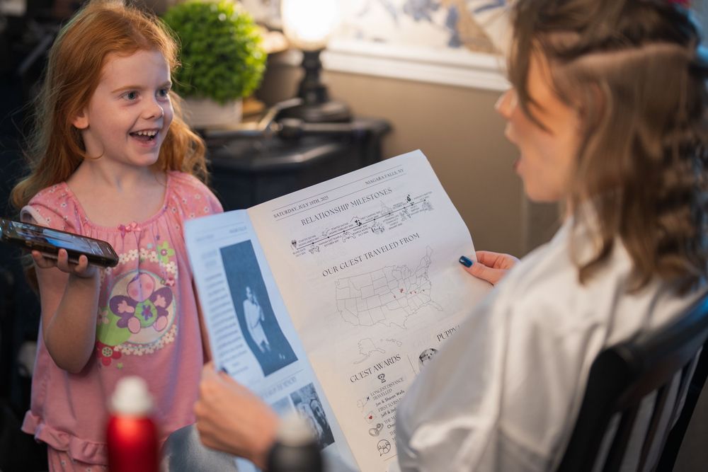 Two children look excitedly at a document or certificate being held between them.
