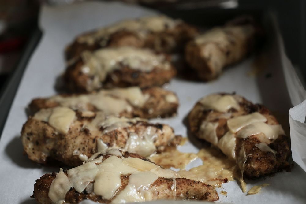 Homemade chocolate chip scones with drizzled white glaze arranged on a baking sheet.