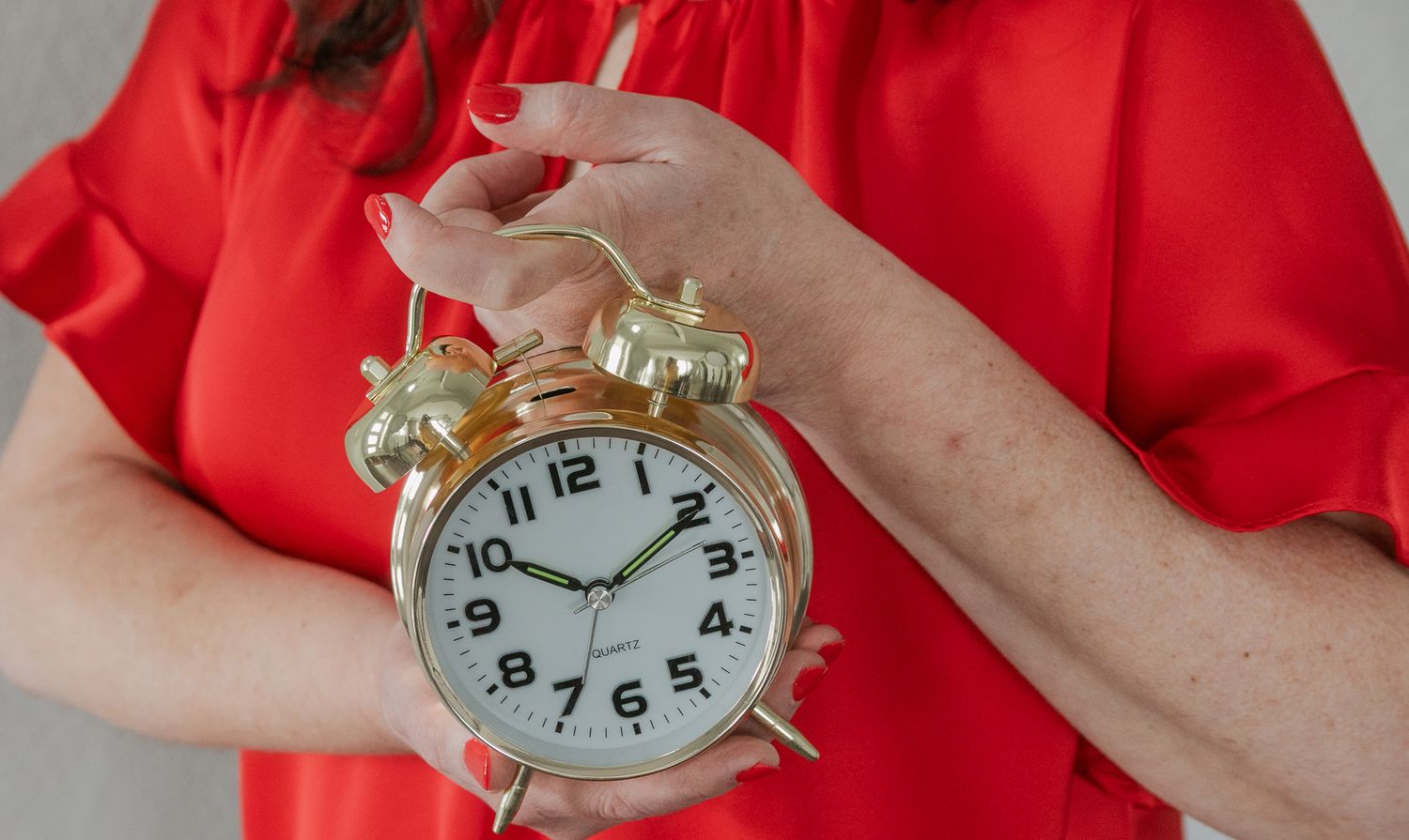 A client photo with the client holding a clock to be used to illustrate time management techniques, using the client's brand colors.