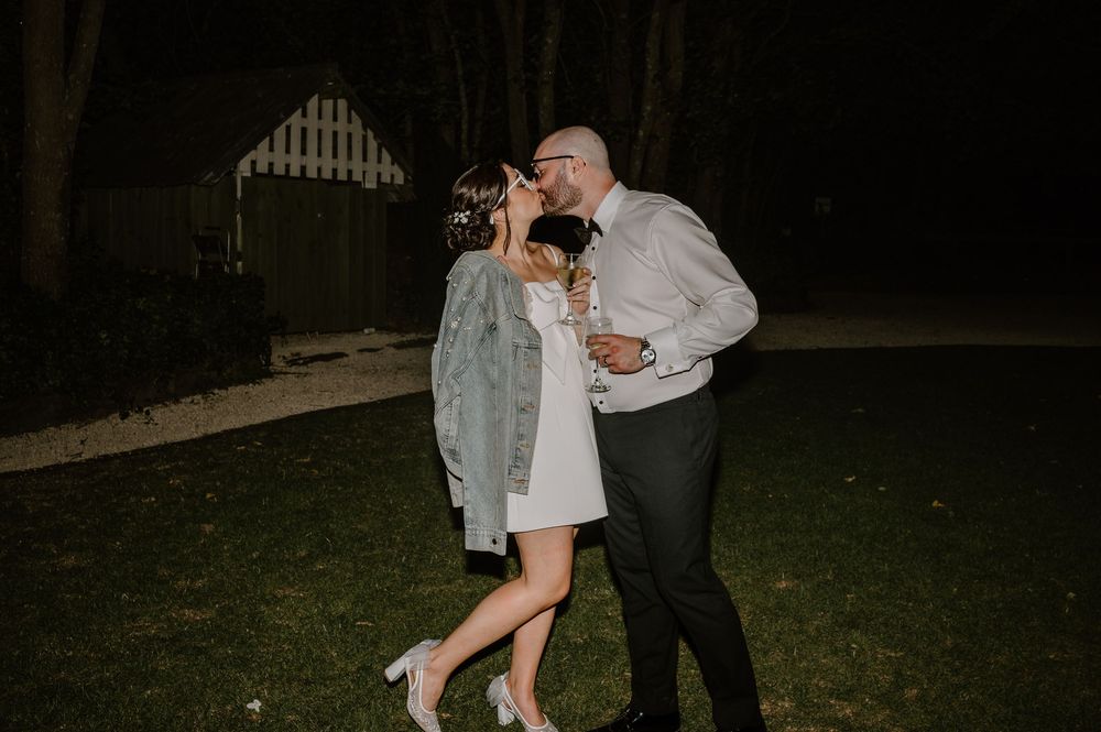 A couple dancing on a backyard lawn at night during what appears to be a romantic celebration.