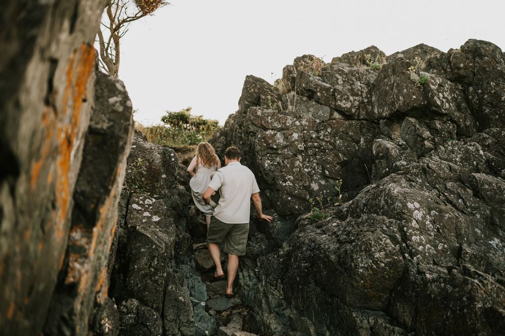Candid photo of family walking through rock beach at Neck Point Park Nanaimo golden hour family photography by Vancouver Island photographer