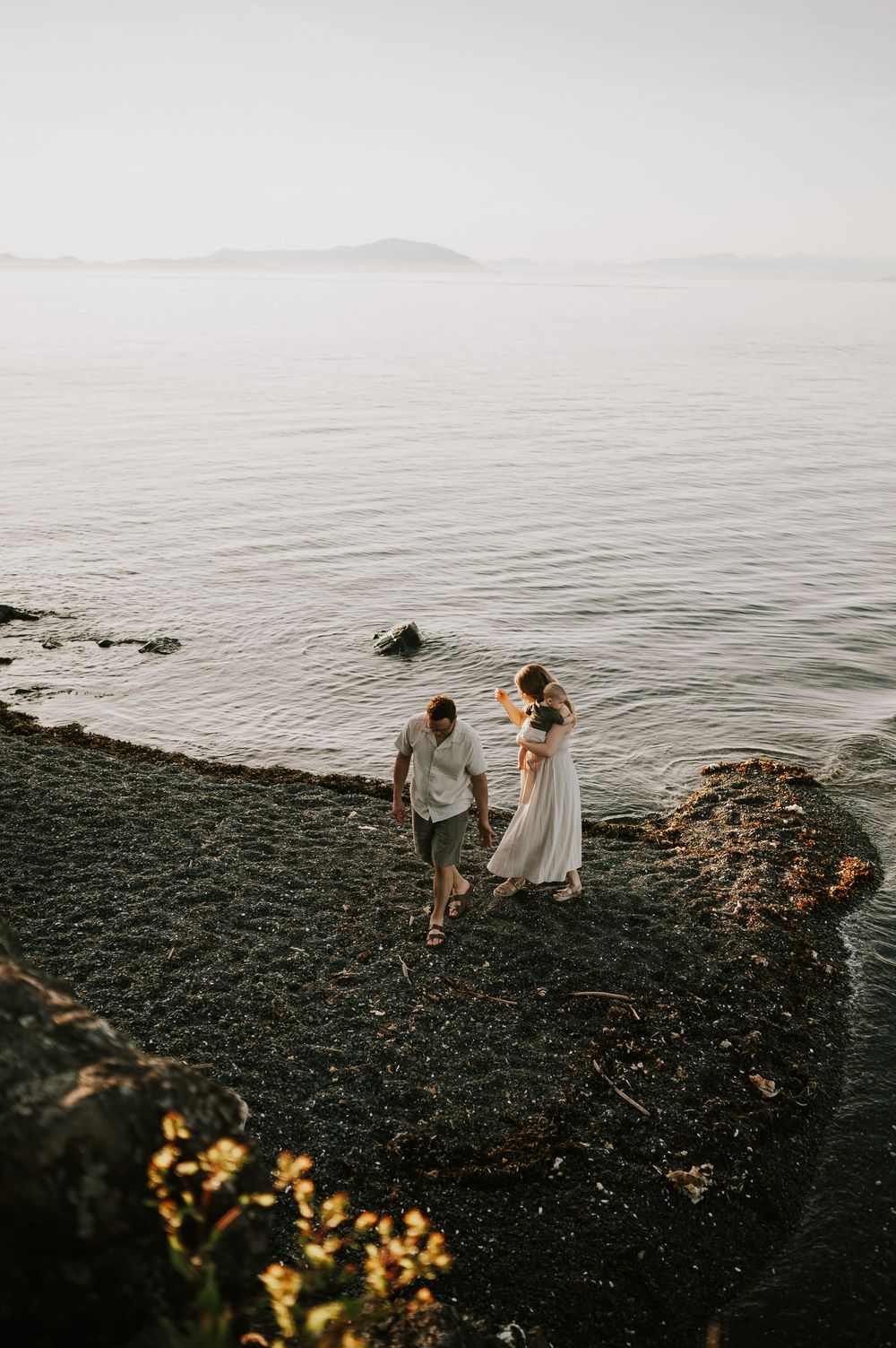 Candid photo of family looking for rocks on ocean shore Neck Point Park Nanaimo sunset family photography by Vancouver Island photographer