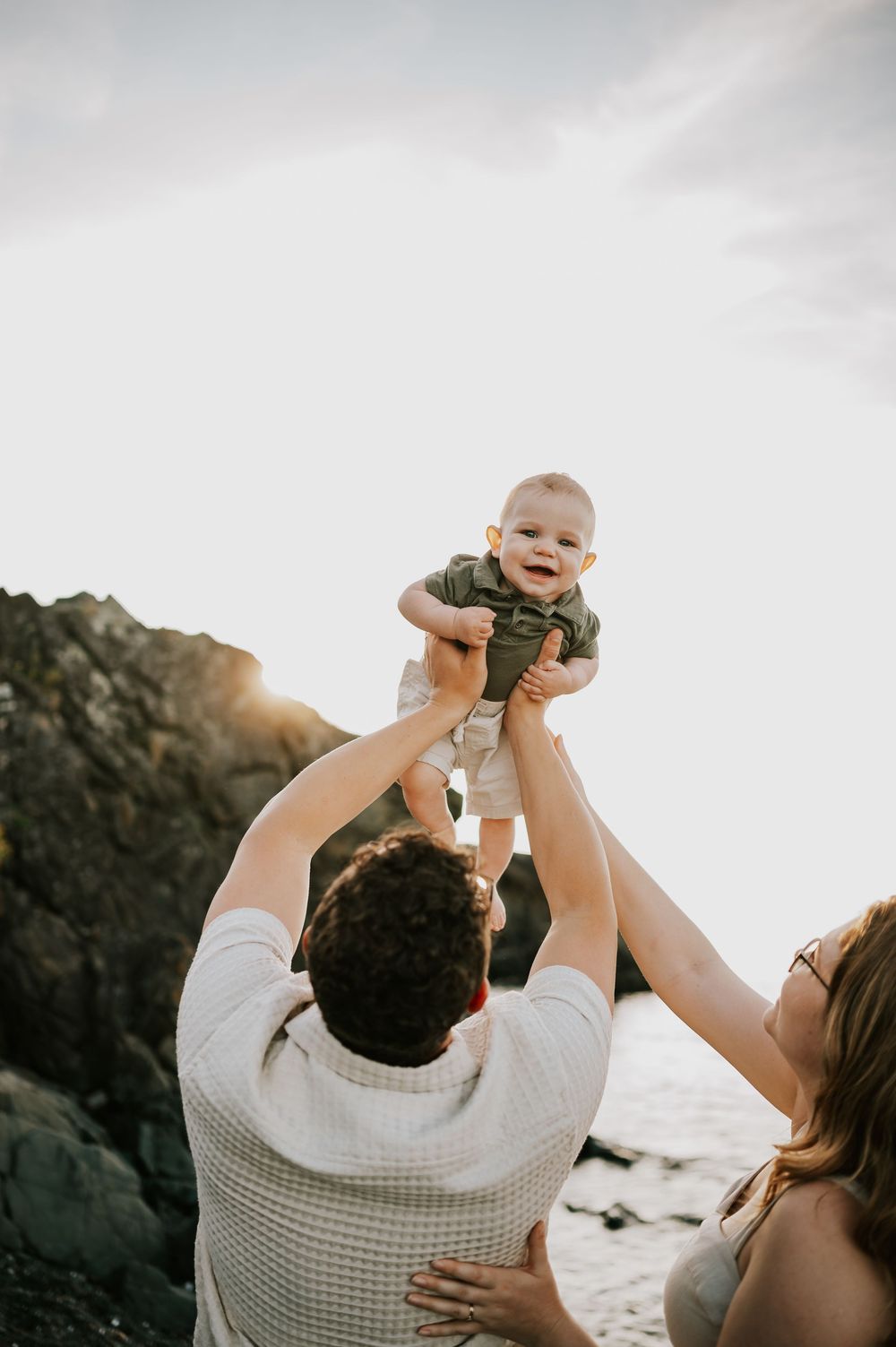 Family photo of baby laughing in air beach at Neck Point Park Nanaimo golden hour family photography by Vancouver Island photographer