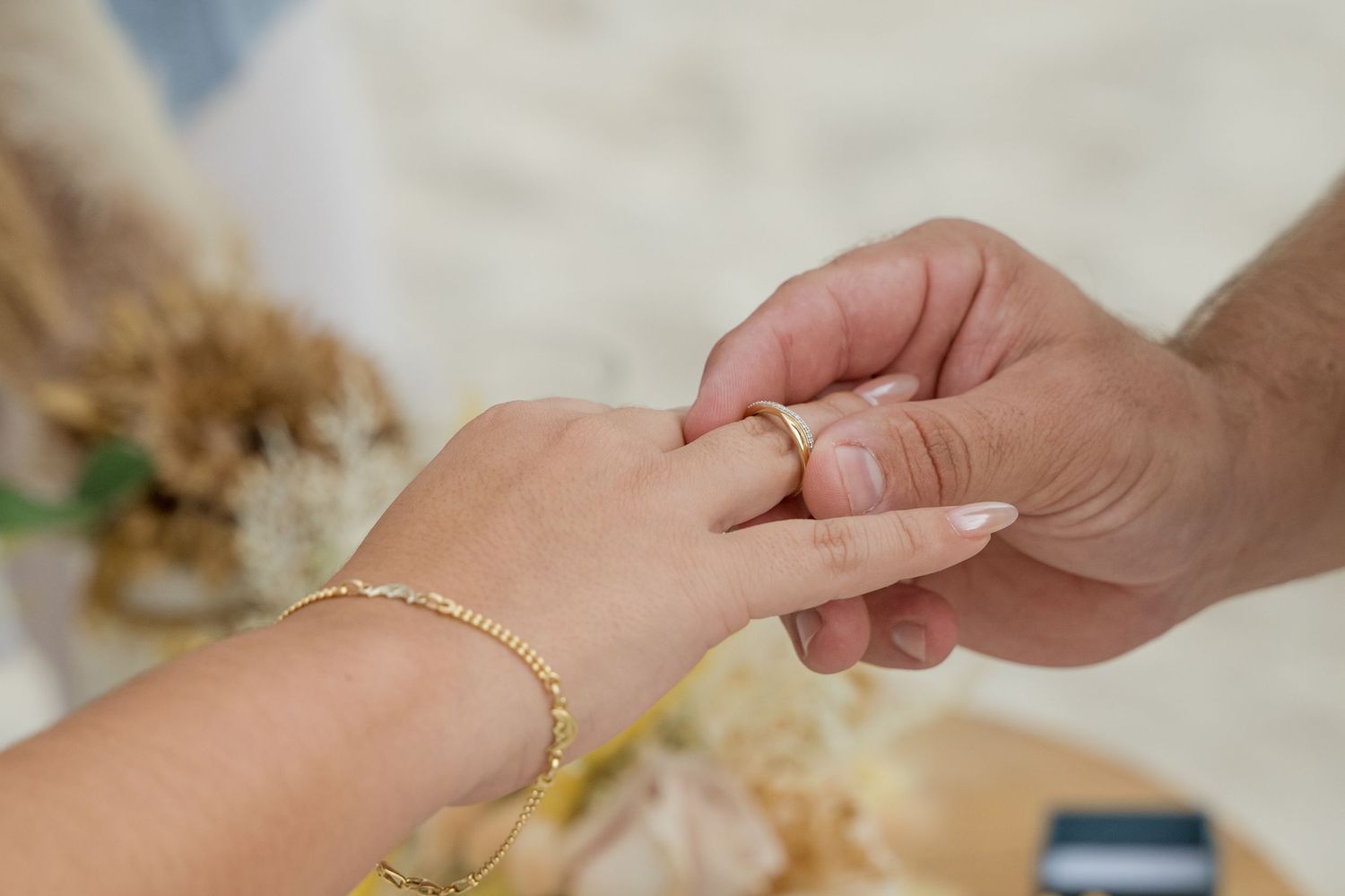 Close-up view of hands preparing dough by mixing flour and butter together on a wooden surface.