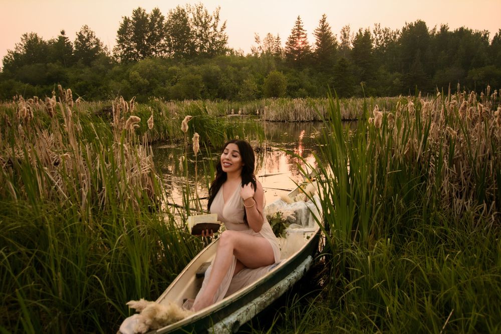Outdoor bathtub scene with rustic aesthetic surrounded by natural wetland vegetation at twilight.