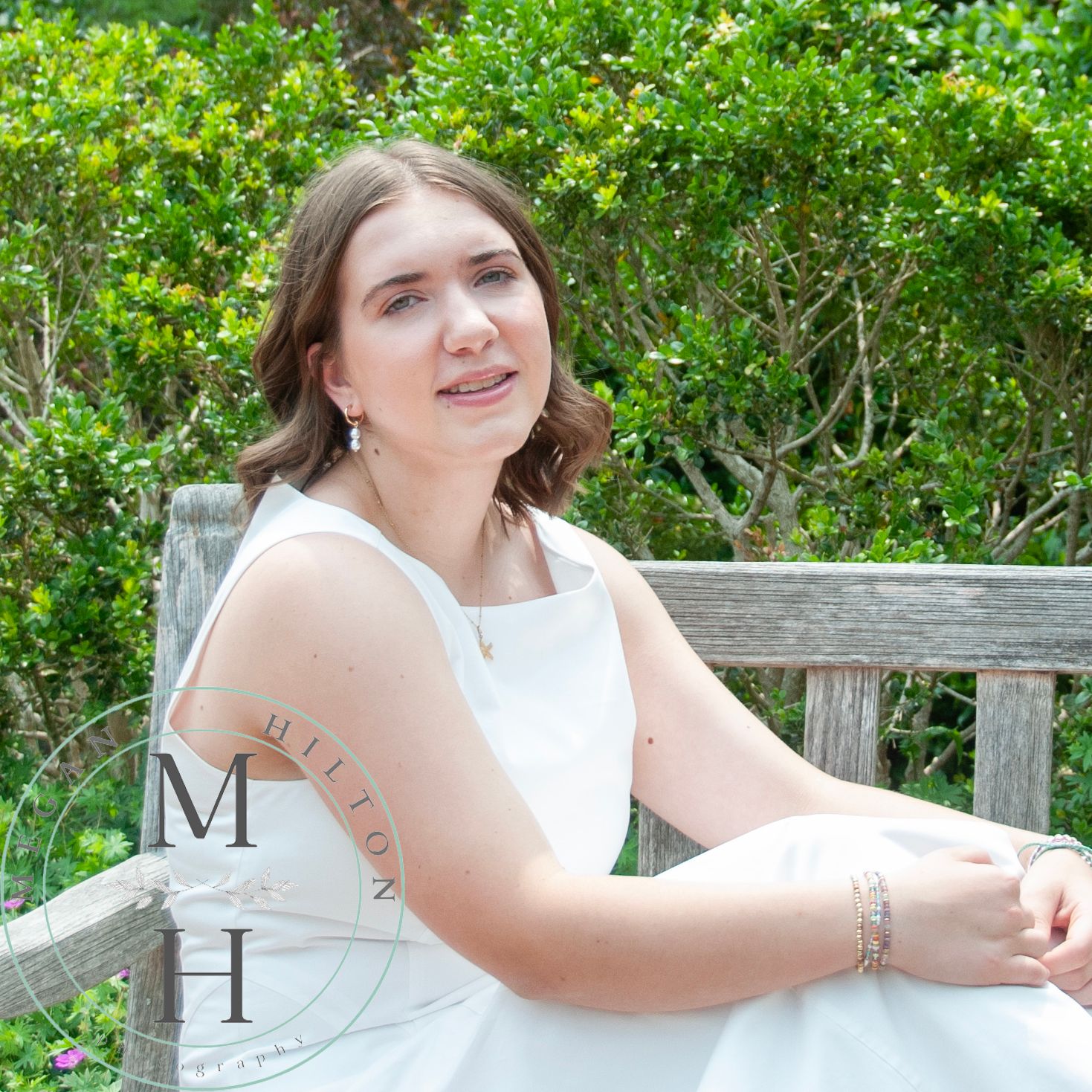 A person in white sits casually on a wooden bench outdoors surrounded by lush greenery in multiple poses.