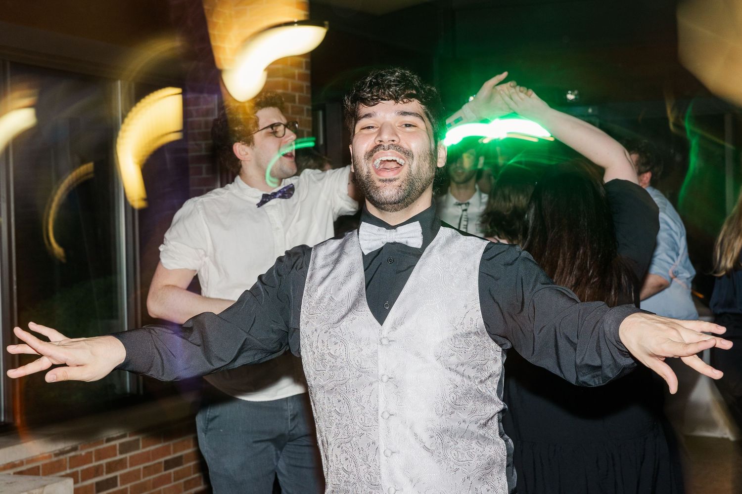 People celebrating on a dance floor at a party with motion blur and festive lighting.
