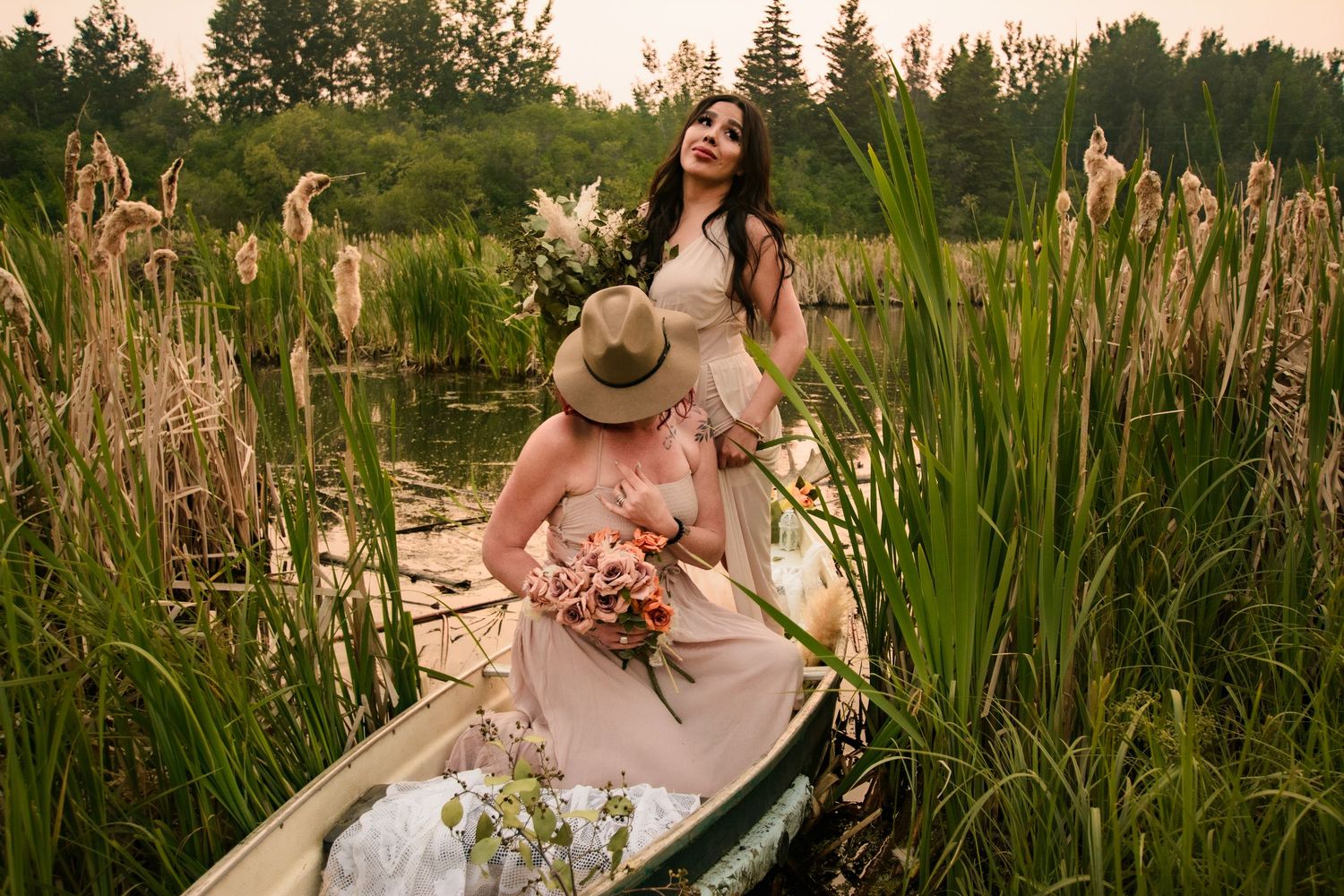 A beautiful sunset couples photoshoot in a field of tall grass and wildflowers creates a romantic summer atmosphere.